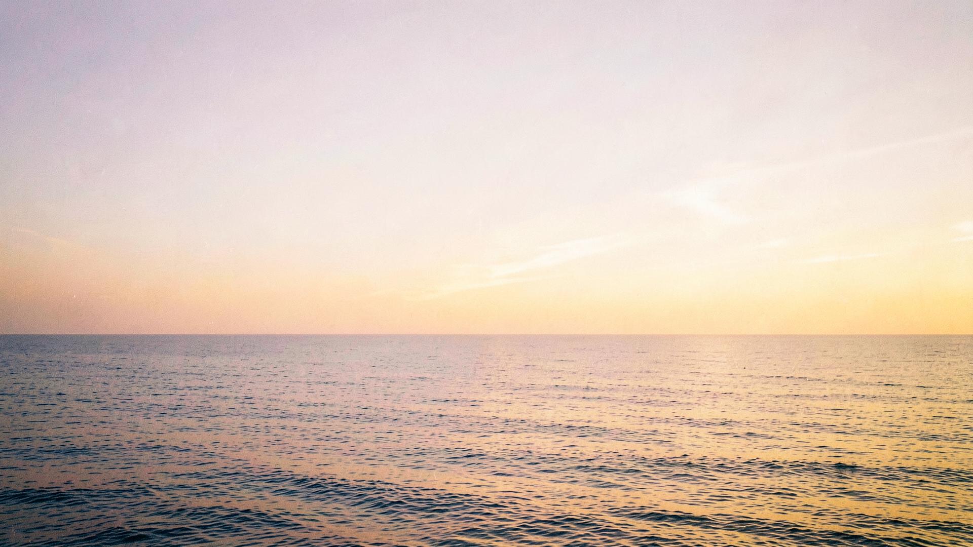 Golden sunrise over a calm ocean horizon